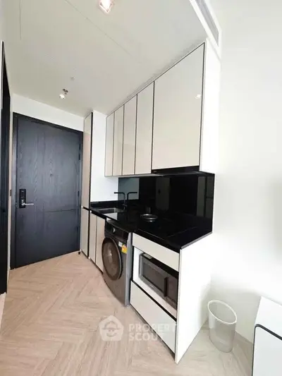 Modern kitchen with sleek cabinetry, built-in appliances, and stylish black accents.