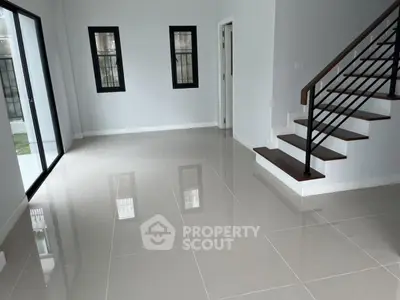 Spacious modern living room with sleek staircase and large windows