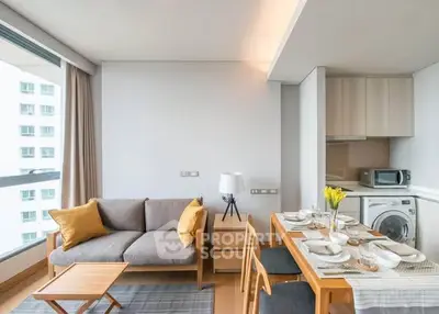 Modern living room with dining area, large window, and stylish furniture in a bright apartment.