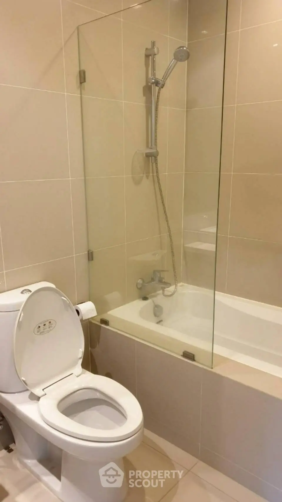 Modern bathroom with glass-enclosed bathtub and sleek fixtures.