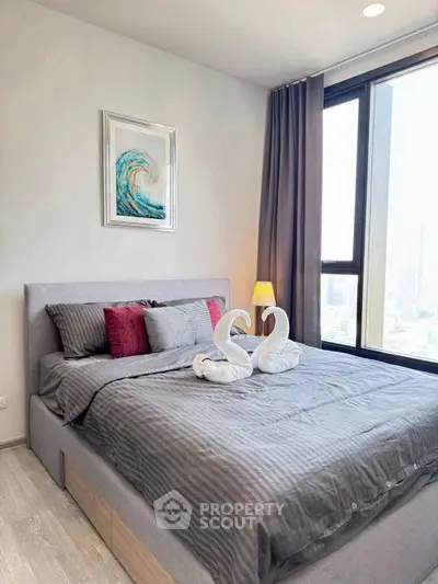 Modern bedroom with stylish decor and large window offering city views