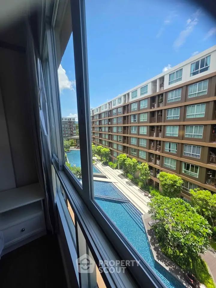 Stunning condo view with pool and lush greenery, perfect for modern living.