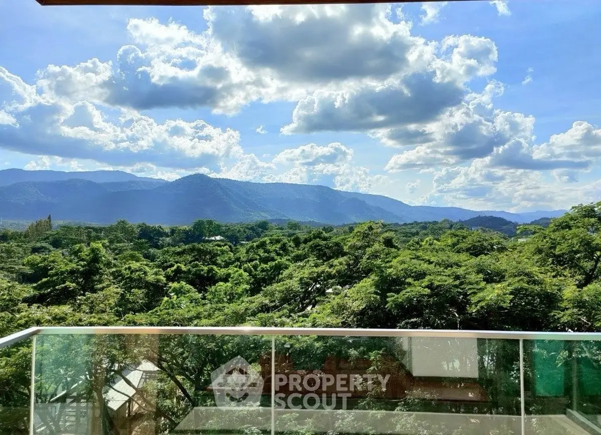 Stunning balcony view overlooking lush green landscape and mountains under a vibrant sky.