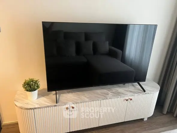 Modern living room with sleek TV on stylish console and cozy sofa, perfect for relaxation.