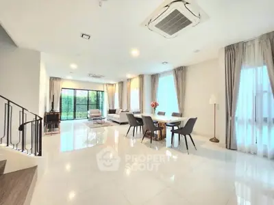 Spacious modern living room with elegant dining area and large windows for natural light.