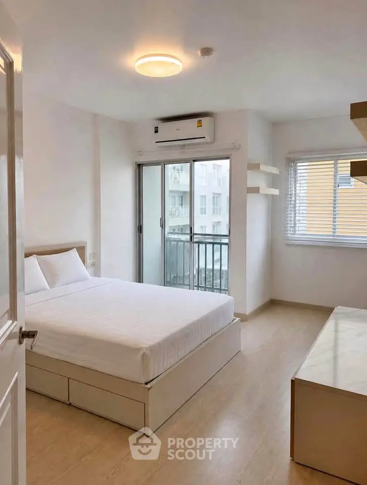 Modern bedroom with balcony access and natural light in a stylish apartment.