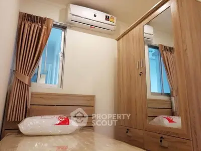 Cozy bedroom with wooden furniture and air conditioning in modern apartment.