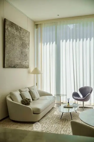 Elegant living room with modern furniture and large windows for natural light.