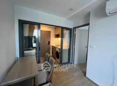 Modern apartment with compact kitchen and laundry area, featuring sleek design and efficient use of space.