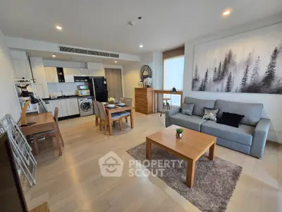 Spacious modern living room with open kitchen, featuring stylish decor and natural light.