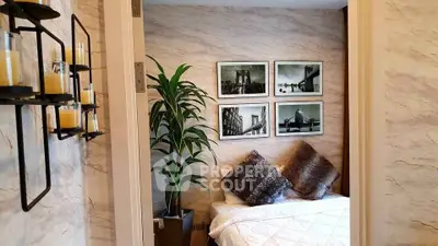 Cozy bedroom with stylish decor and wall art, featuring plush pillows and a potted plant for a serene ambiance.