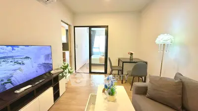 Modern living room with cozy decor and open view to bedroom, featuring stylish furniture and natural light.