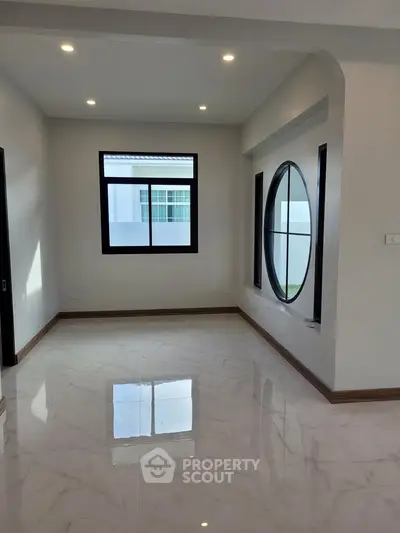 Modern interior with large circular window and marble flooring