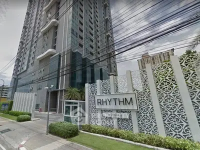 Modern high-rise condominium building with stylish facade and lush landscaping at Rhythm Sukhumvit.