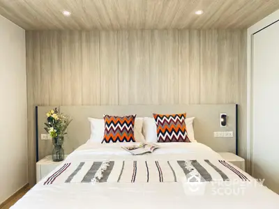 Modern minimalist bedroom with stylish wooden wall paneling and vibrant accent pillows, offering a serene and chic sleeping space.