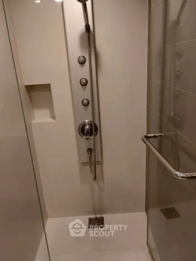 Modern shower area with sleek fixtures and glass door in a contemporary bathroom.
