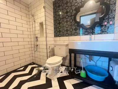 Stylish bathroom with modern black and white tile design and elegant fixtures.