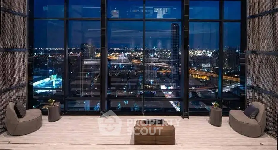 Luxurious high-rise apartment with stunning city skyline view at night, featuring modern seating area.