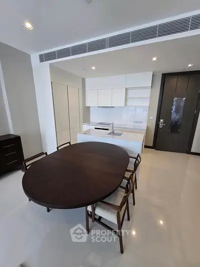 Modern kitchen with sleek design and dining area in luxury apartment.