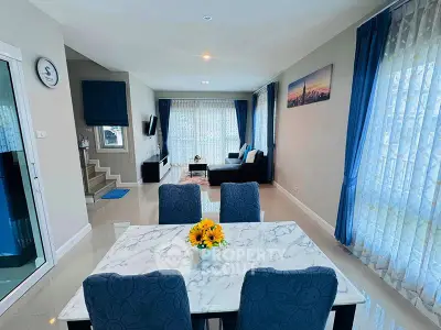 Elegant open-plan living and dining area with modern decor and natural light.