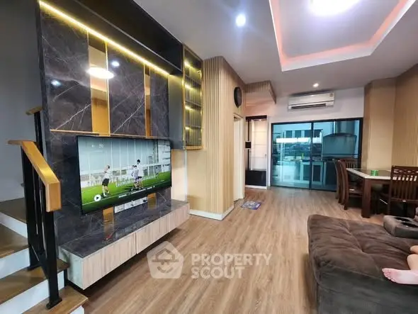 Modern living room with stylish decor, wooden flooring, and a cozy seating area, perfect for relaxation.