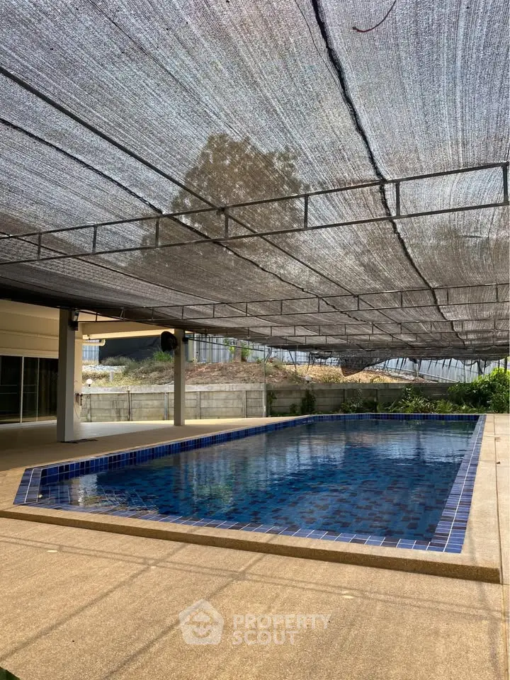 Luxurious covered swimming pool area with modern design and ample natural light, perfect for relaxation and leisure.