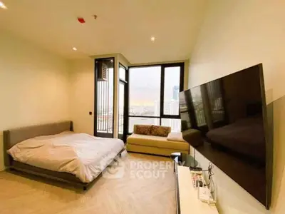 Modern bedroom with large TV and city view from window, featuring cozy bed and stylish decor.