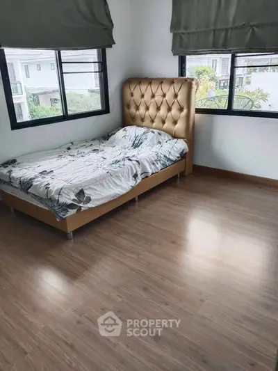 Spacious bedroom with elegant bed and large windows offering natural light and scenic views.