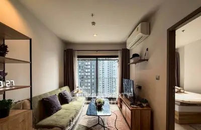 Modern living room with city view, featuring cozy sofa and stylish decor in high-rise apartment.