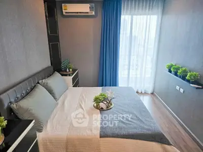 Modern bedroom with stylish decor and city view from large window.