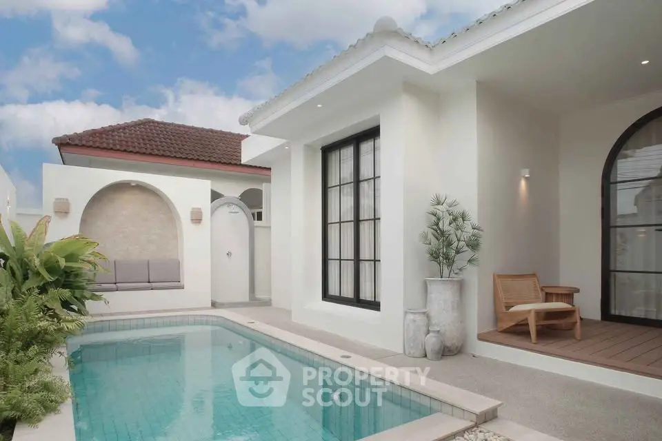 Luxurious villa with private pool and modern outdoor seating area under a clear blue sky.