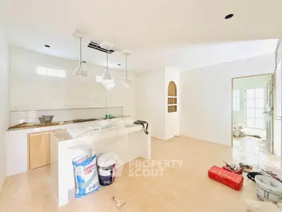 Bright and spacious kitchen under renovation with modern lighting and open layout.