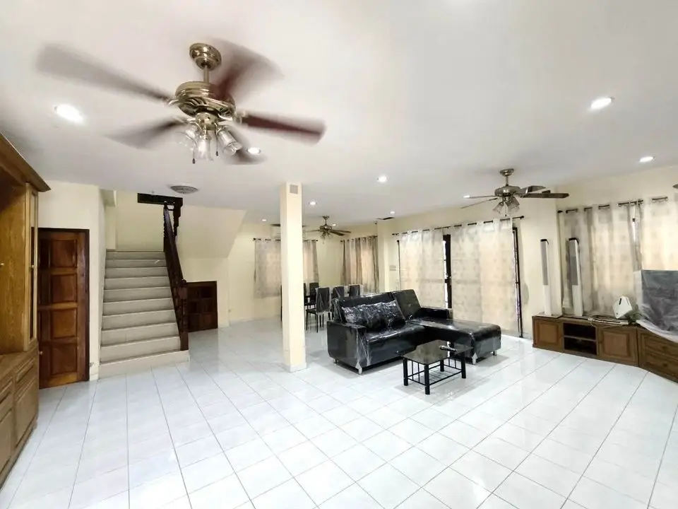 Spacious living room with modern furniture and ceiling fans in a bright open layout.