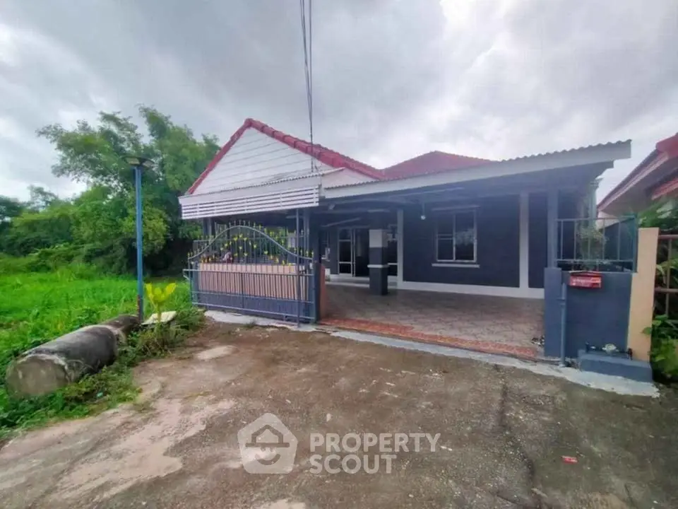 Charming single-story house with red roof and spacious driveway in a serene neighborhood.