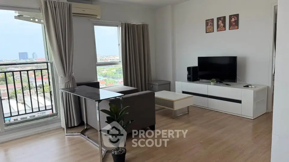Modern living room with balcony view, sleek furniture, and abundant natural light in a high-rise apartment.