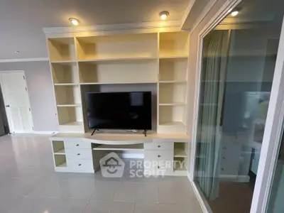 Spacious living room with built-in shelving and modern TV setup