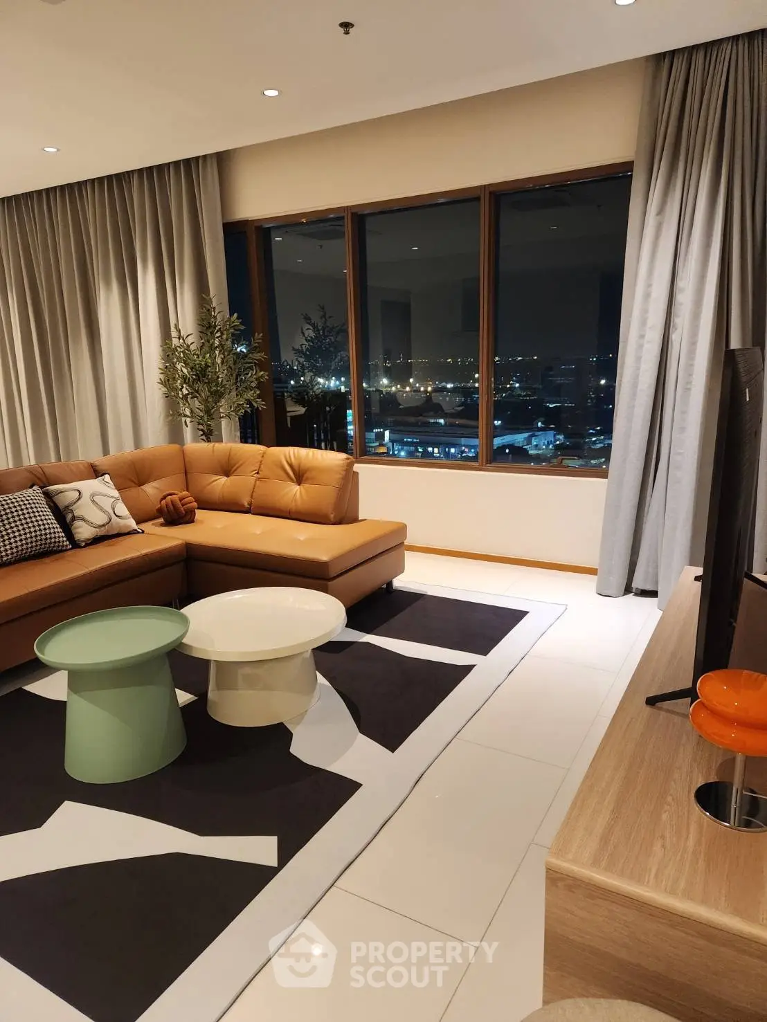 Luxurious living room with stunning night city view, modern furniture, and elegant decor.