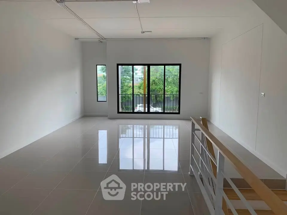 Spacious modern living room with large windows and sleek tile flooring