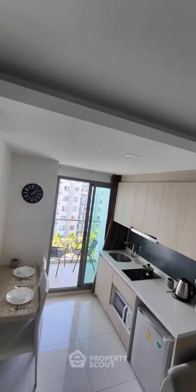 Modern kitchen with balcony view in high-rise apartment