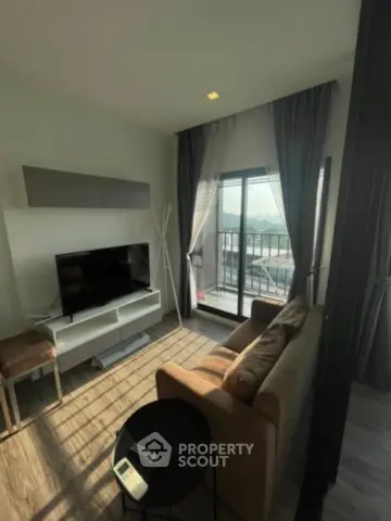 Modern living room with balcony view, stylish furniture, and natural light.