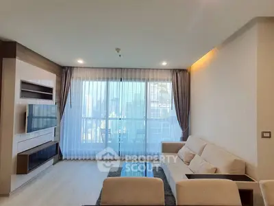 Spacious modern living room with large windows and city view.