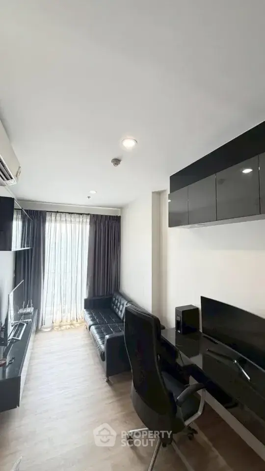 Modern study room with sleek black furniture and natural light from large window.