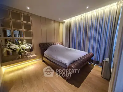 Luxurious bedroom with elegant decor and ambient lighting, featuring a plush bed and stylish wall paneling.