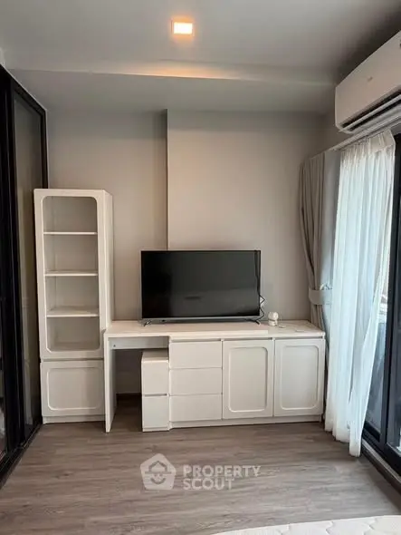 Modern living room with sleek TV unit and large window for natural light
