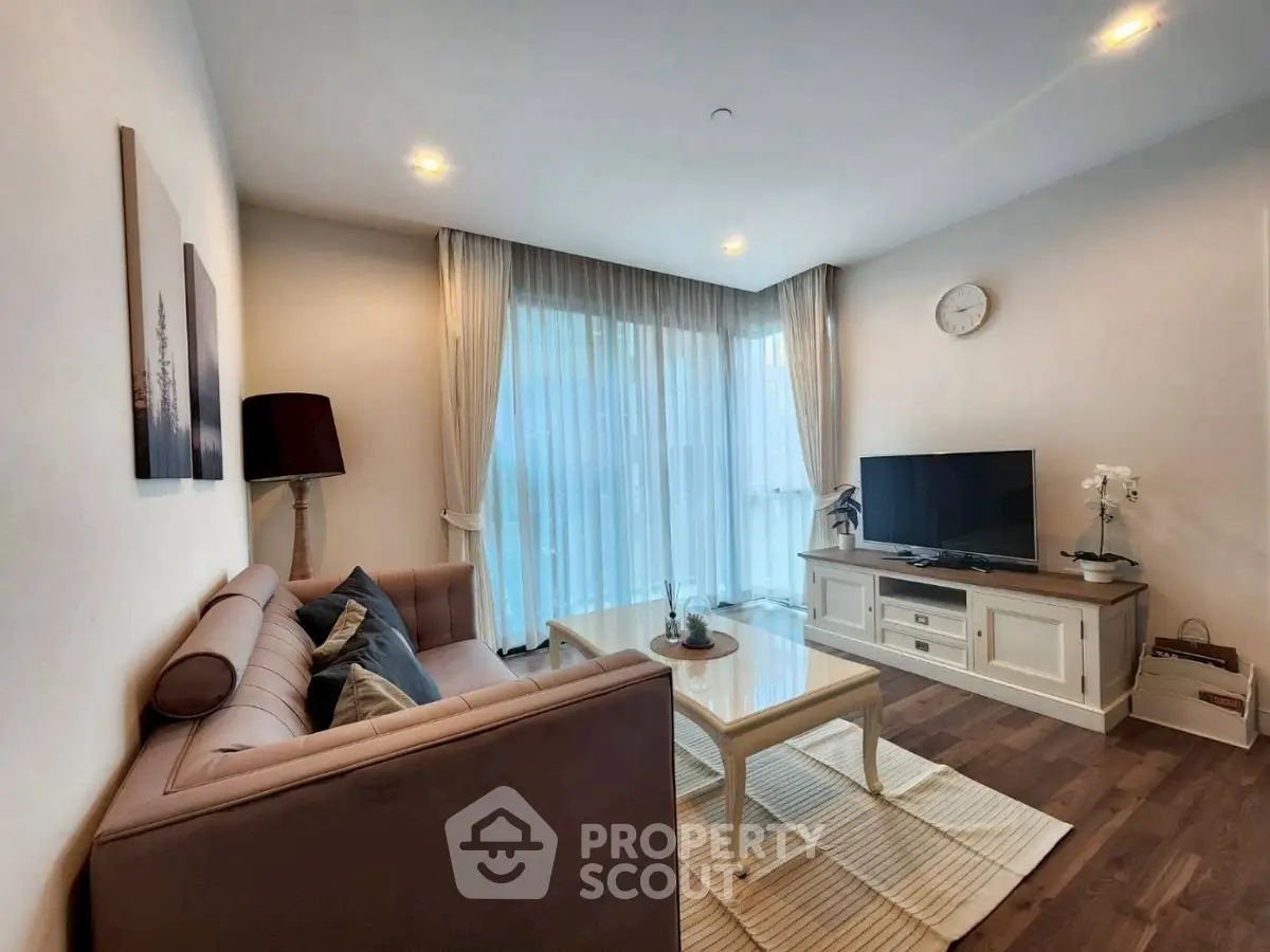 Elegant living room with modern decor, cozy sofa, and large windows for natural light.