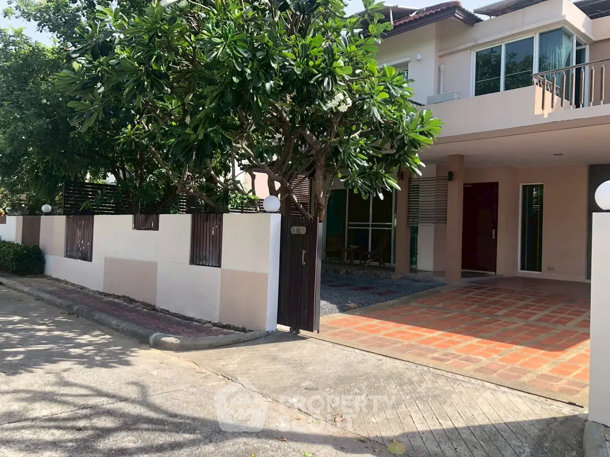 Charming suburban home with spacious driveway and lush greenery, perfect for family living.