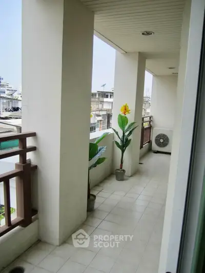 Spacious balcony with city view and decorative plants in modern apartment