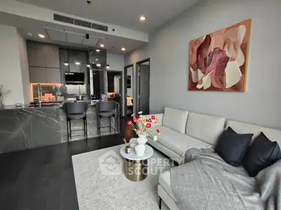 Modern living room with open kitchen, stylish decor, and cozy seating area.