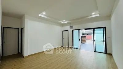 Spacious modern living room with sliding glass doors and wooden flooring