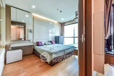 Spacious modern bedroom with wooden flooring and large window for natural light.